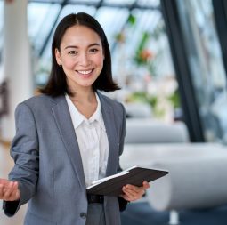 Happy,Young,Asian,Saleswoman,Looking,At,Camera,Welcoming,Client.,Smiling